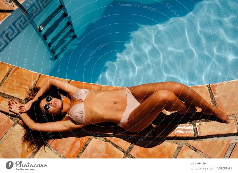 Relaxed woman sunbathing on the edge of a swimming pool Lifestyle Happy Beautiful Body Hair and hairstyles Skin Relaxation Swimming pool Leisure and hobbies