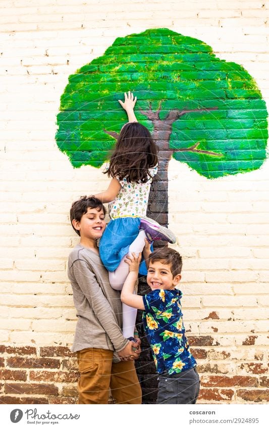 Three kids playing with a tree painted on a wall Joy Happy Beautiful Leisure and hobbies Playing Freedom Summer Garden Climbing Mountaineering Child School