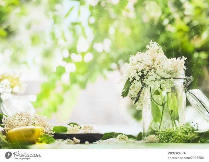 Elderberry blossoms in glass on kitchen table with lemon and sugar. Food Nutrition Organic produce Beverage Juice Crockery Style Design Healthy Healthy Eating