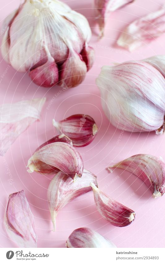 Fresh garlic on a light pink background Vegetable Herbs and spices Vegetarian diet Decline Garlic bulb ingrerient Clove food health healthy Organic Raw Minimal