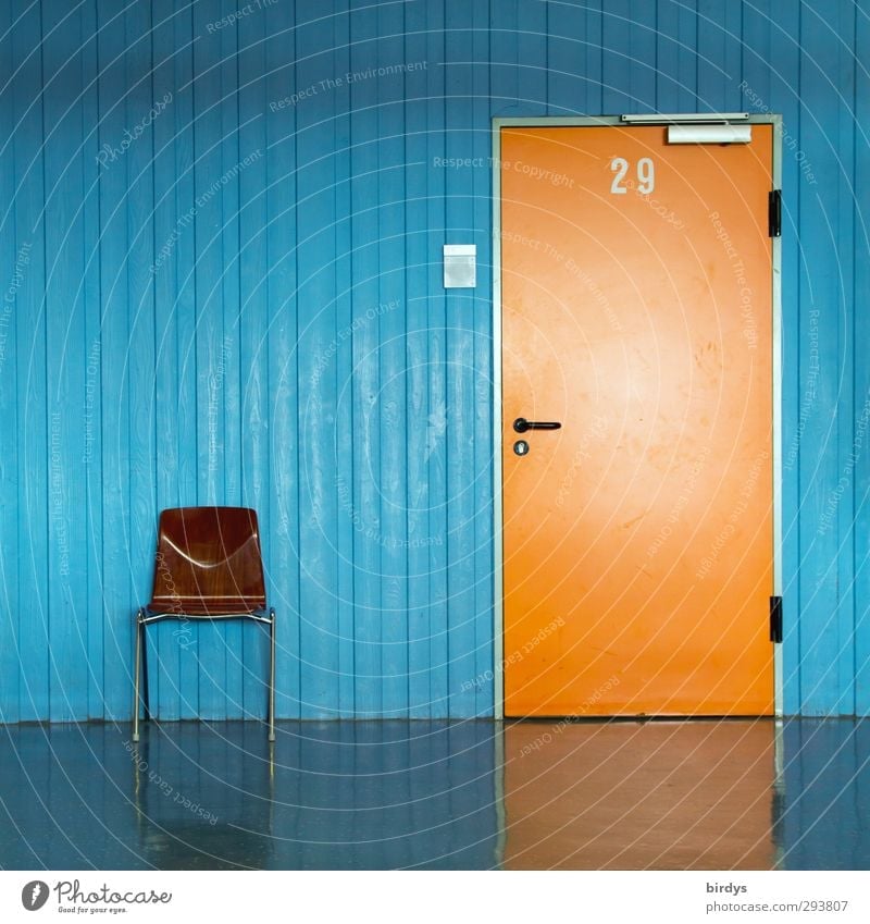 Orange door with number 29 and door sign in blue wall and a chair for waiting people in front of it. Office Chair Classroom Hallway Entrance Digits and numbers