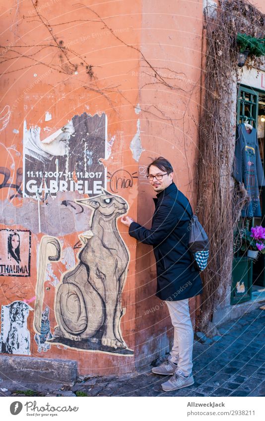 Young man interacts with street art on house wall Italy Rome Sightseeing City trip Town Vantage point Travel photography Vacation & Travel Trip Wall (building)
