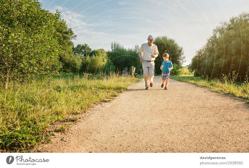 Senior man and happy child running on nature path Joy Happy Leisure and hobbies Playing Summer Child Human being Boy (child) Man Adults Grandfather