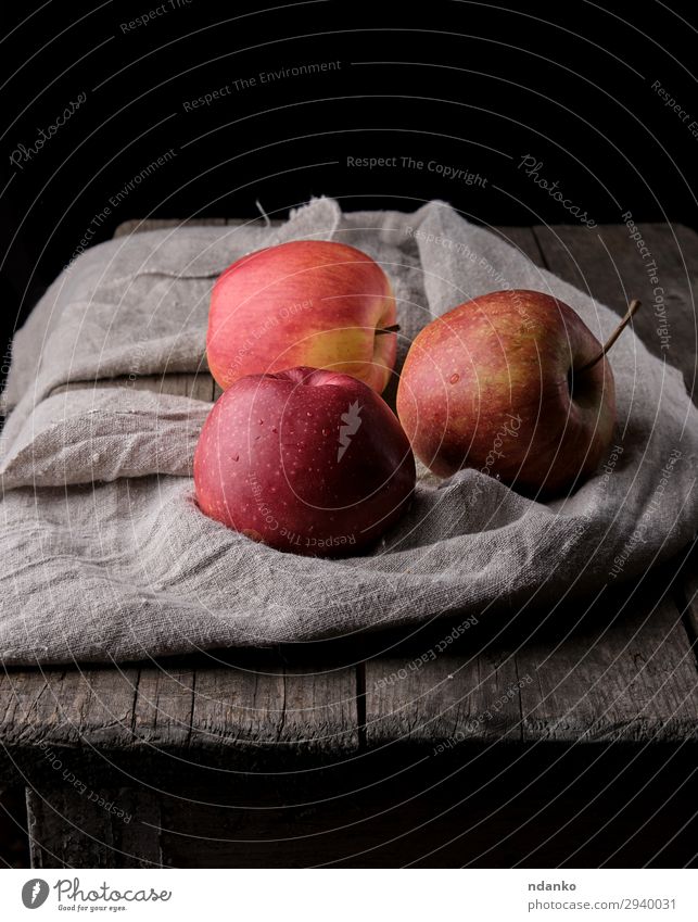 three fresh red apples lay on gray linen napkin Fruit Apple Dessert Nutrition Vegetarian diet Diet Table Nature Plant Autumn Wood Fresh Natural Juicy Gray Red