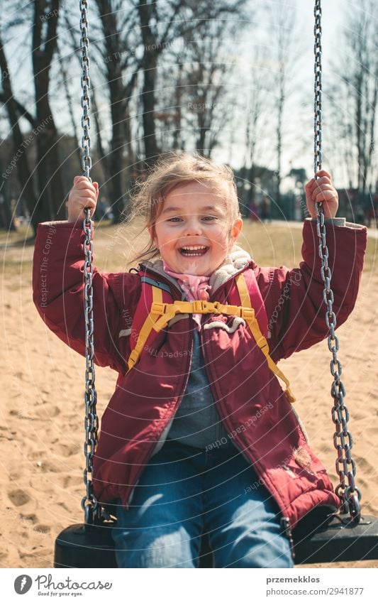 Little smiling happy girl swinging in a park on sunny spring day. Child looking at camera wearing red jacket Lifestyle Joy Happy Beautiful Playing Summer Woman