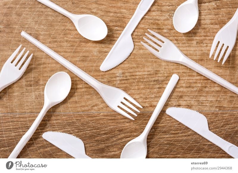 Disposable plastic cutlery on wooden table. Top view Kitchen Plastic Table Crockery Recycling empty Environment Fork garbage Group Industrial Birthday knife