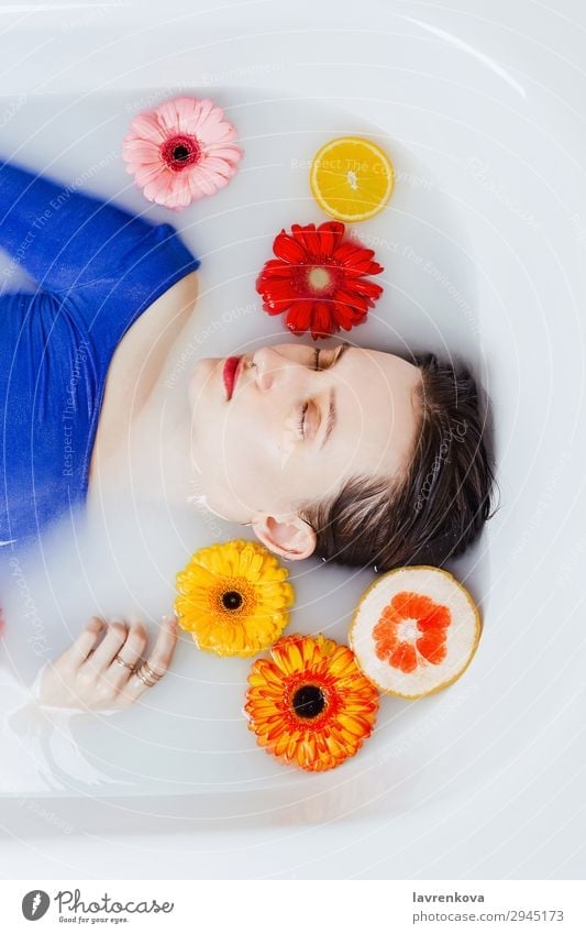 Woman lying in bathtub filled with flowers and fruits Swimming & Bathing Bathroom Bathtub Beautiful Beauty Photography Flower Blue Citrus fruits Decoration