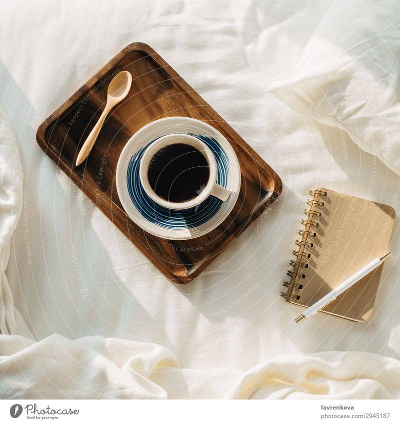 Coffee on wooden tray with notebook and pen on bed Neutral Background Bedroom Beverage Breakfast Brown Cup flat flatlay Hot Morning Mug Notebook Paper Pen