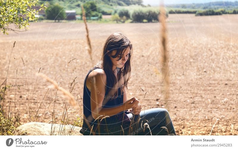 Portrait of a young, sad woman sitting in front of a field in summer Lifestyle Style Senses Calm Vacation & Travel Trip Adventure Far-off places Freedom
