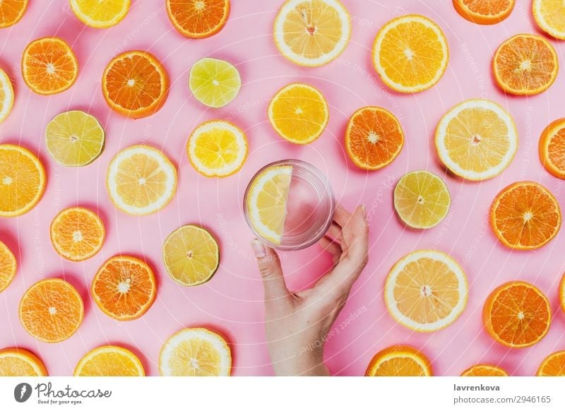woman's hand holding lemon water with sliced citrus fruits Pink Woman flat lay sassy water Hold Hand Cut Lime Round Diet Vegetarian diet Food Healthy Eating