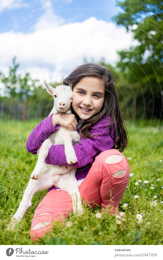 Little girl hugging a goat on a field Lifestyle Happy Beautiful Leisure and hobbies Playing Vacation & Travel Summer Summer vacation Garden Child Schoolchild