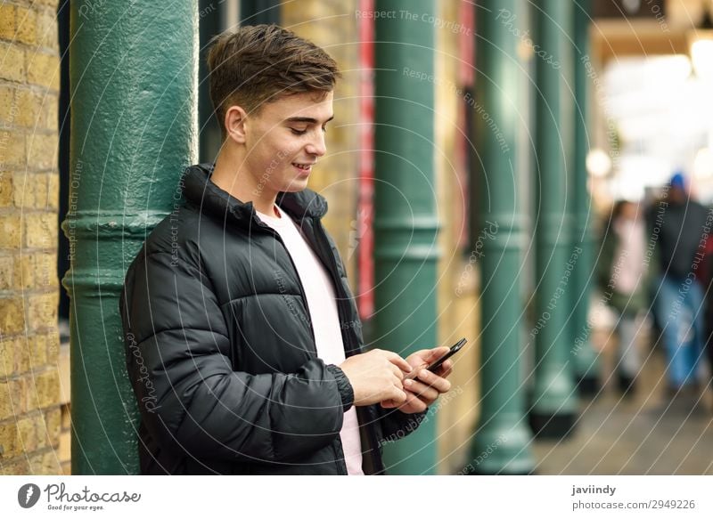 Young urban man using smartphone in urban background. Lifestyle Style Happy Telephone PDA Technology Human being Masculine Young man Youth (Young adults) Man