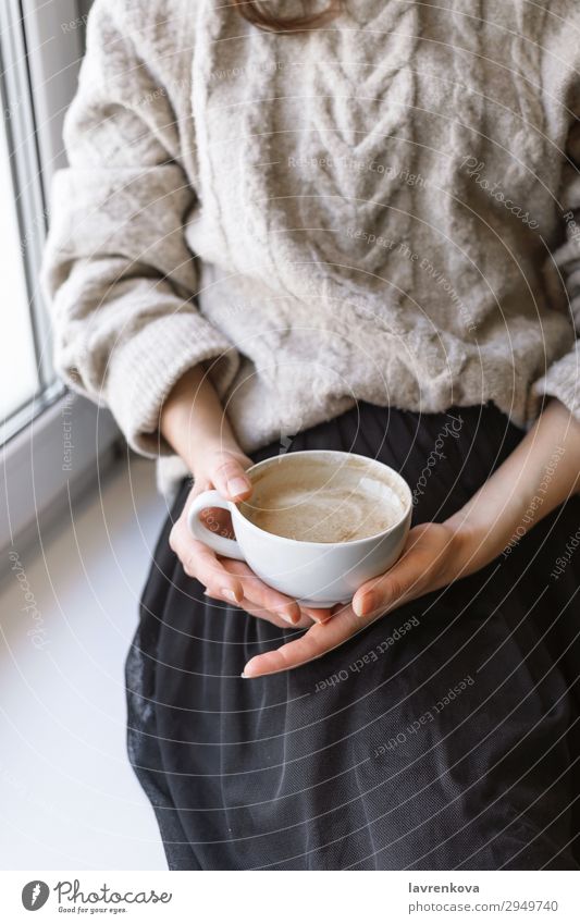 woman's holding cup with latte in front of the window Autumn Winter Relaxation Sweater Breakfast Interior shot Hand Cup Mug Warmth Cozy Café Close-up Coffee