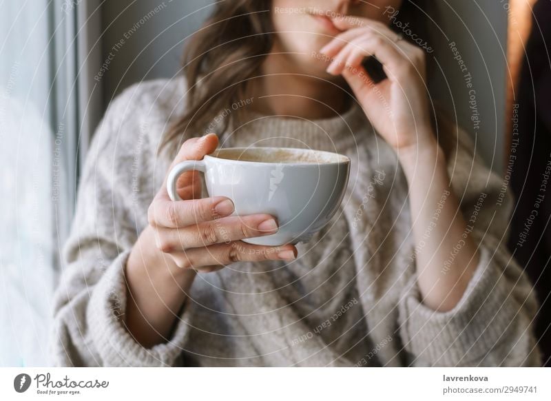 woman's holding cup with latte in front of the window selective focus Café Close-up Coffee Cup Beverage Drinking Woman Shallow depth of field Young woman Home