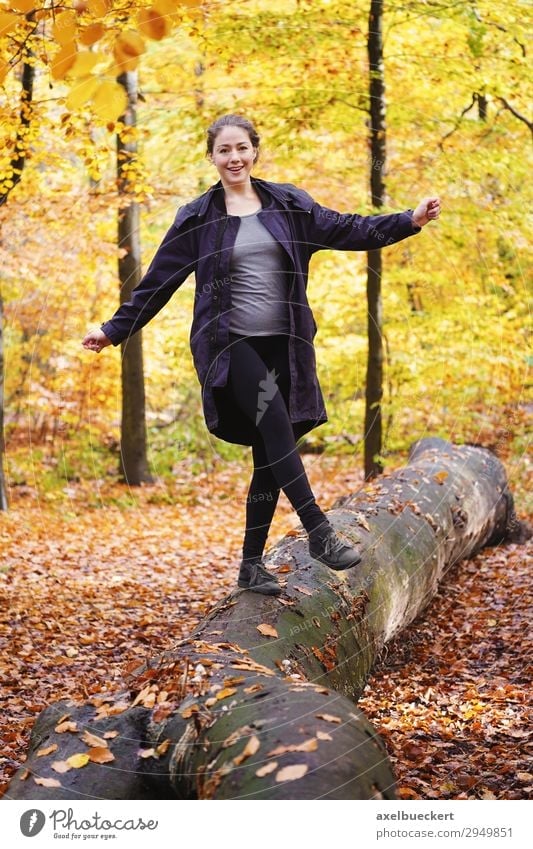 young woman balancing on tree trunk in autumn forest Lifestyle Joy Leisure and hobbies Human being Feminine Young woman Youth (Young adults) Woman Adults 1