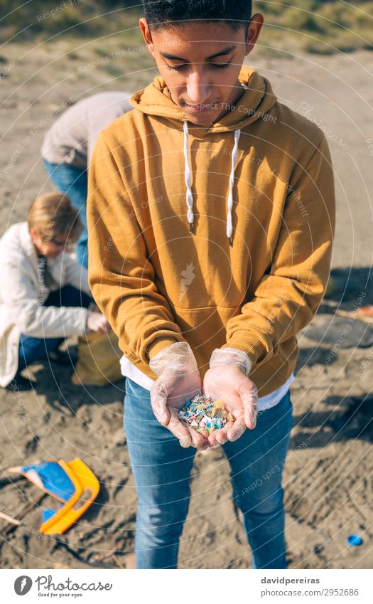 Young man showing microplastics Beach Human being Man Adults Hand Group Environment Sand Plastic Old Dangerous Teamwork Environmental pollution Indicate