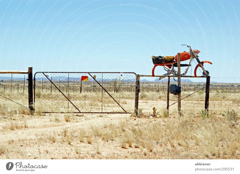 entrenched Environment Nature Landscape Plant Elements Earth Sky Cloudless sky Summer Warmth Grass Bushes Desert Old Gate Motorcycle Steppe Grating Colour photo