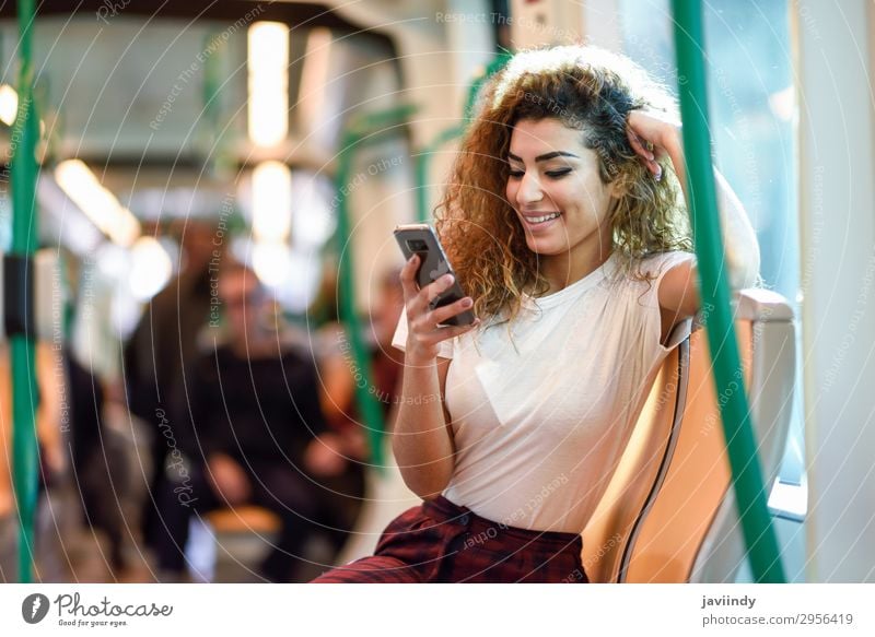 Arab woman inside subway train looking at her smartphone Lifestyle Happy Beautiful Hair and hairstyles Vacation & Travel Tourism Trip Telephone PDA Human being