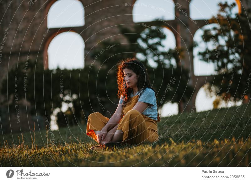 Young woman resting at sunset Lifestyle Well-being Relaxation Meditation Human being Feminine Youth (Young adults) 1 18 - 30 years Adults Nature Summer Park
