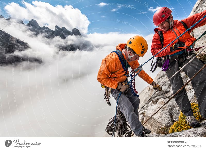 Team of climbers rappelling. Adventure Climbing Mountaineering Man Adults 2 Human being 30 - 45 years Clouds Storm Helmet Self-confident Brave Determination