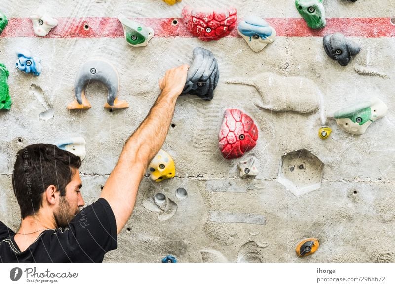 Man practicing rock climbing on artificial wall indoors. Lifestyle Joy Leisure and hobbies Sports Climbing Mountaineering Masculine Young man