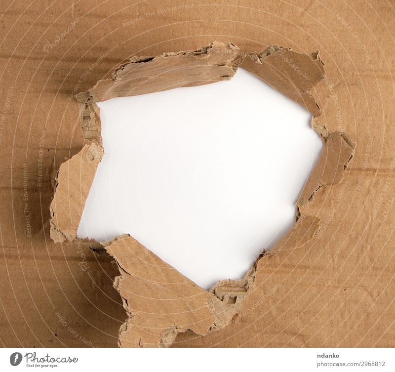 brown sheet of paper with a hole, full frame Design Paper Old Under Brown White Idea background Blank border break Bullet Cardboard circle Conceptual design