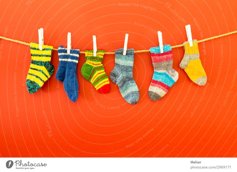 Colourful socks on a clothesline on a red background Style Design Winter Fashion Fresh Retro Warmth Soft Blue Multicoloured Green Red White Diligent Cleanliness
