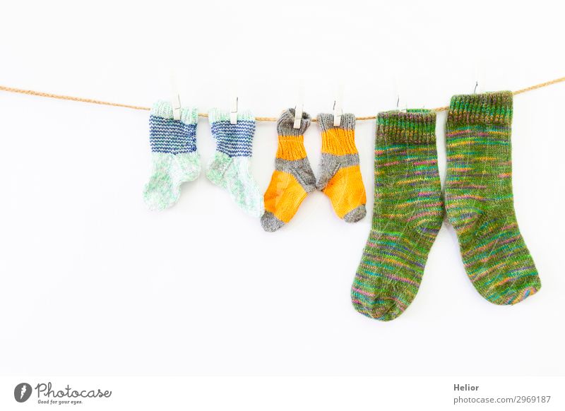 Colourful socks on a clothesline on a white background Style Design Handcrafts Knit Winter Fashion Fresh Retro Warmth Soft Yellow Green White Orderliness