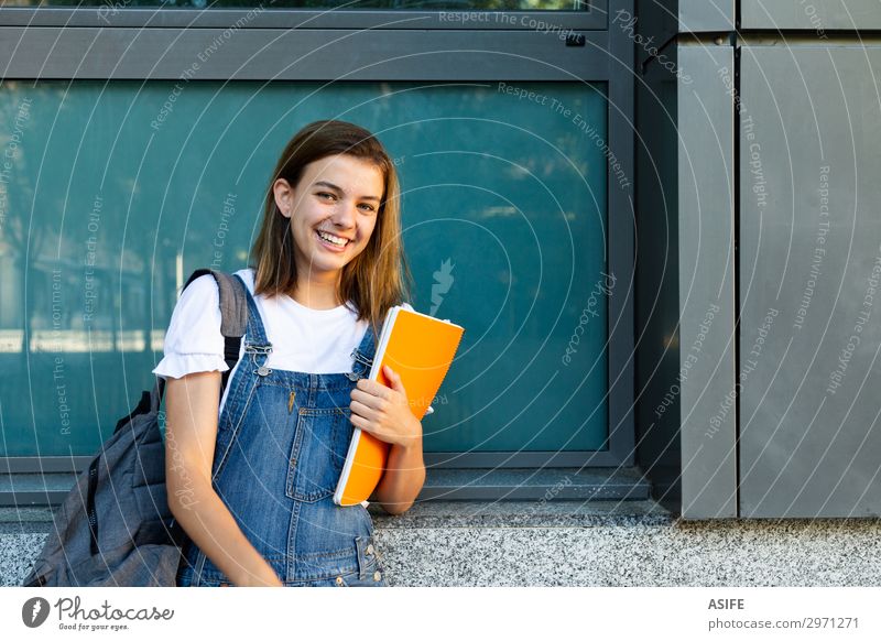 Portrait of a happy student girl leaning against the window of the school Lifestyle Happy Beautiful School Academic studies Woman Adults Youth (Young adults)