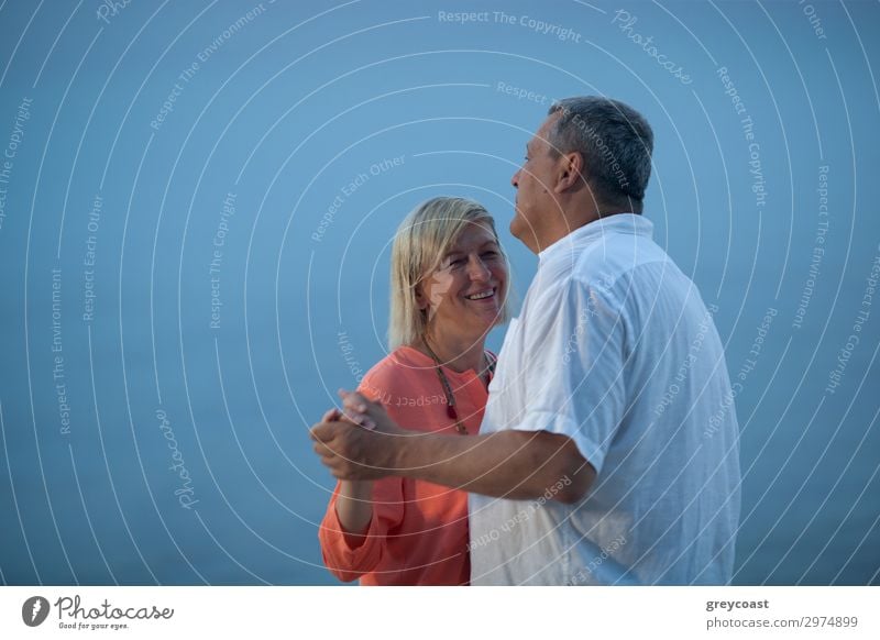 A middle-aged couple dances slightly in front of the blue sky turning into sea Leisure and hobbies Vacation & Travel Trip Ocean Dance Human being Masculine