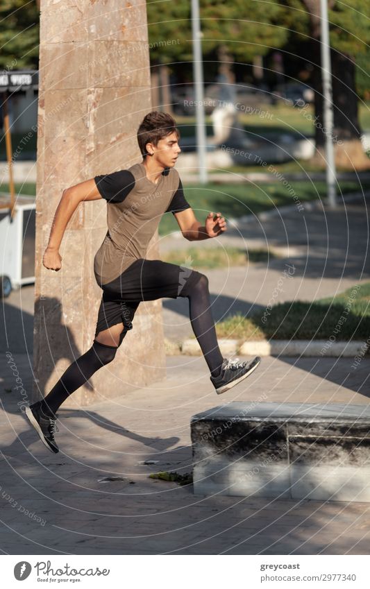 A teenage boy goes in for parkour in a city park Sports Track and Field Jogging Human being Masculine Young man Youth (Young adults) 1 13 - 18 years T-shirt