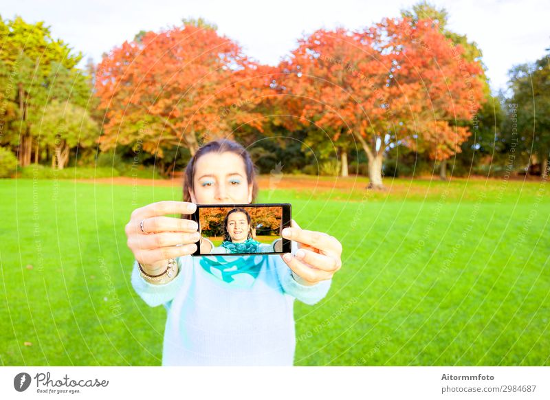 Woman taking selfie Lifestyle Happy Beautiful Vacation & Travel Telephone PDA Camera Internet Human being Adults Nature Autumn Park Fashion Smiling Happiness