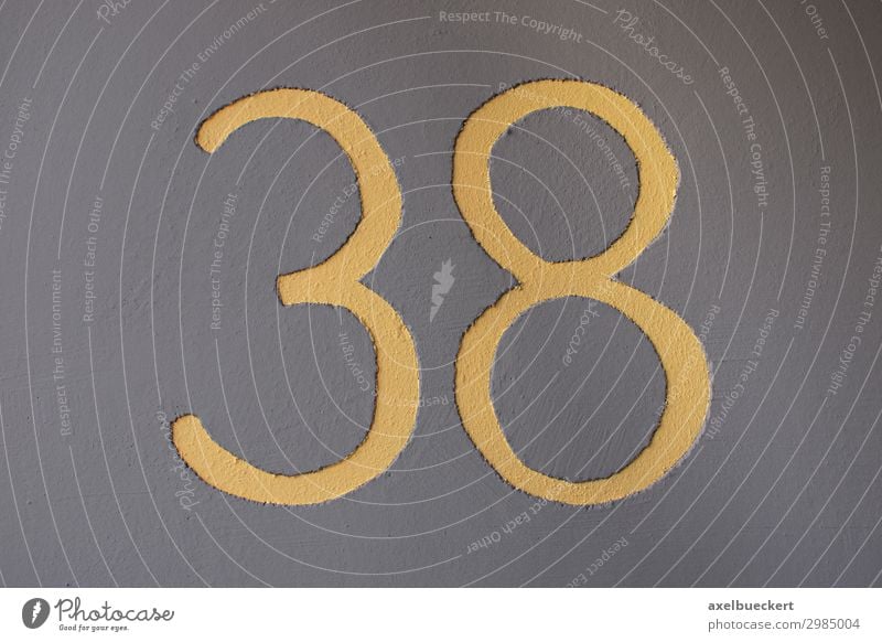 yellow number 38 on grey wall - house number thirty-eight Wall (barrier) Wall (building) Yellow Gray Symbols and metaphors Digits and numbers House number