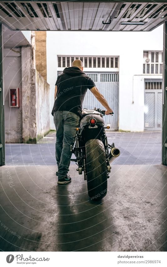 Man with custom motorbike leaving the garage Lifestyle Style Vacation & Travel Trip Engines Human being Adults Street Motorcycle Jeans Bald or shaved head Stand