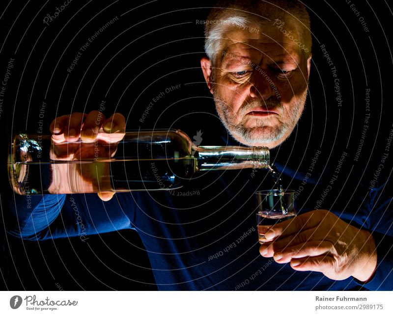 A man pours alcohol into a glass Human being Masculine Man Adults 1 Gray-haired "Bottle Glass Schnaps glass Alcohol" Drinking Alcoholism Addiction "Alcoholism