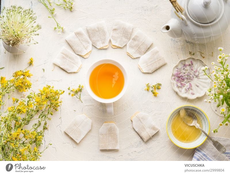 teapot pouring tea into flying cups, on white background Stock