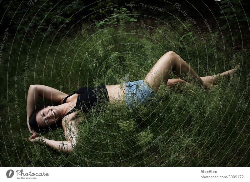 Portrait of a tall young woman lying in the grass and smiling Lifestyle Joy luck already Well-being Young woman Youth (Young adults) 18 - 30 years Adults Nature