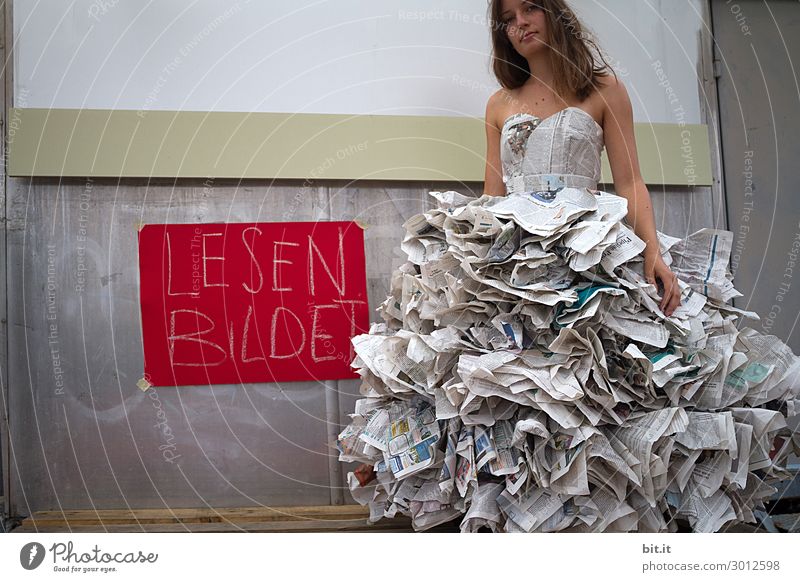 Young woman in a newspaper dress, invited to read. Feminine Youth (Young adults) Adults Art Work of art Theatre Stage Youth culture Media Print media Newspaper