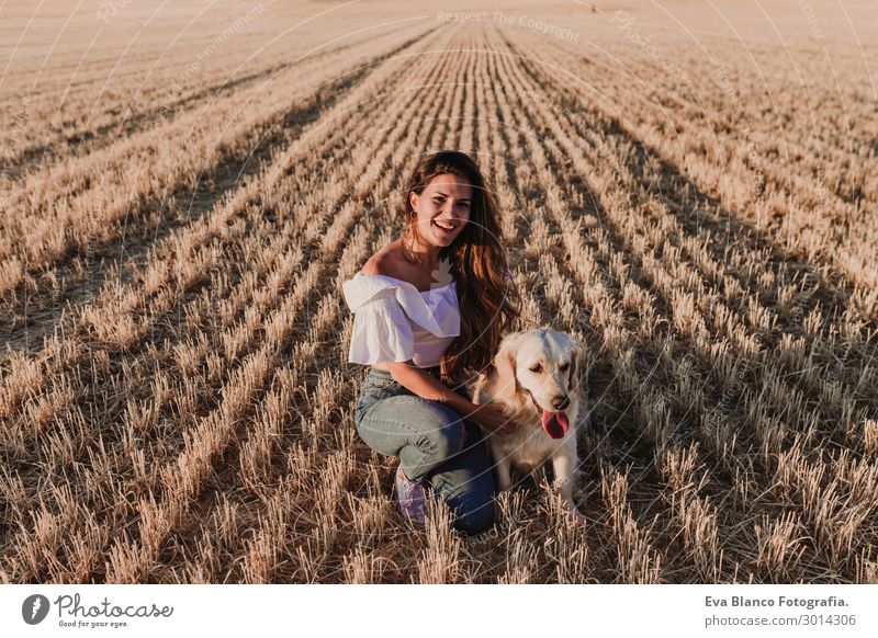 young woman with golden retriever dog on a yellow field Lifestyle Joy Happy Beautiful Harmonious Leisure and hobbies Freedom Summer Sun Feminine Young woman