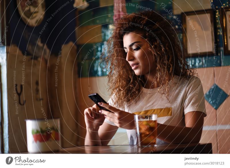 Young arabic woman with black curly hairstyle sitting in a beautiful bar with vintage decoration Beverage Drinking Lifestyle Style Beautiful Hair and hairstyles