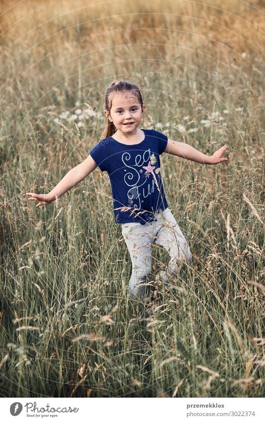 Little happy smiling girl playing in a tall grass Lifestyle Joy Happy Relaxation Vacation & Travel Summer Child Human being Girl 1 3 - 8 years Infancy