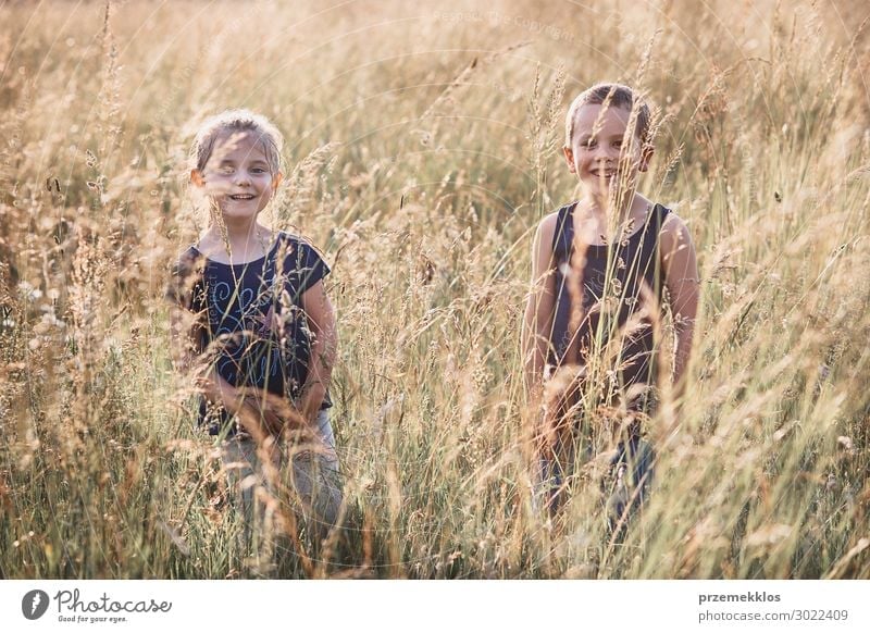 Little cute adorable girl enjoying a cool water sprayed by her mother  during hot summer day in backyard. Candid people, real moments, authentic  situations - a Royalty Free Stock Photo from Photocase