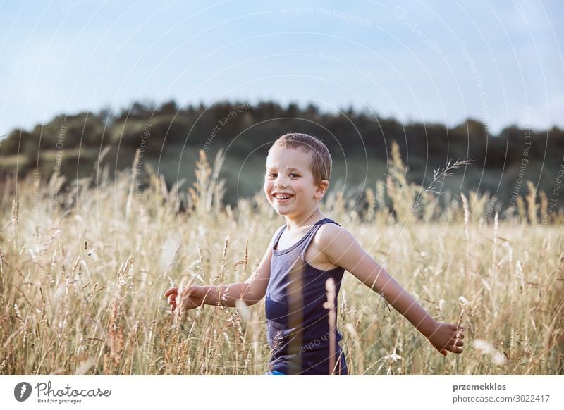Little happy boy walking through a tall grass in the countryside Lifestyle Joy Happy Relaxation Vacation & Travel Summer Summer vacation Child Human being