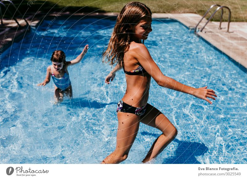 Beautiful little girl swims in the pool , cute little girl in pool in sunny  day.little girl . Stock Photo