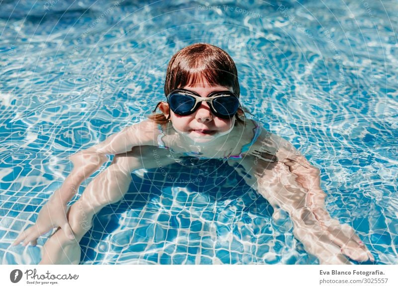 Premium Photo  Little girl in waterproof goggles and a swimsuit at a  swimming class in an indoor pool