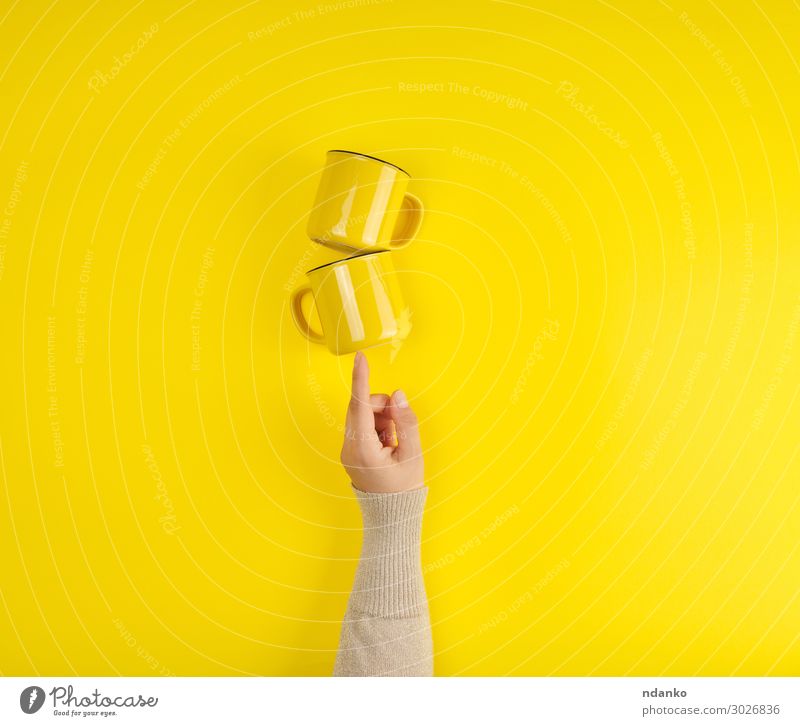 two yellow ceramic cups are supported by a female hand Breakfast Coffee Tea Cup Kitchen Arm Hand Fingers Hot Bright Clean Yellow Colour Hold background Blank