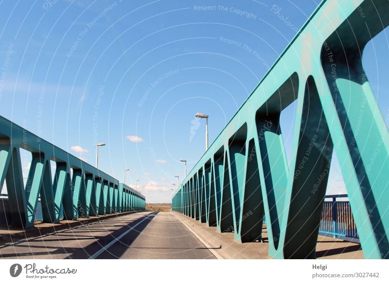 Road with turquoise metal construction of the Peene bridge near Anklam in front of a blue sky Environment Bridge Manmade structures Architecture