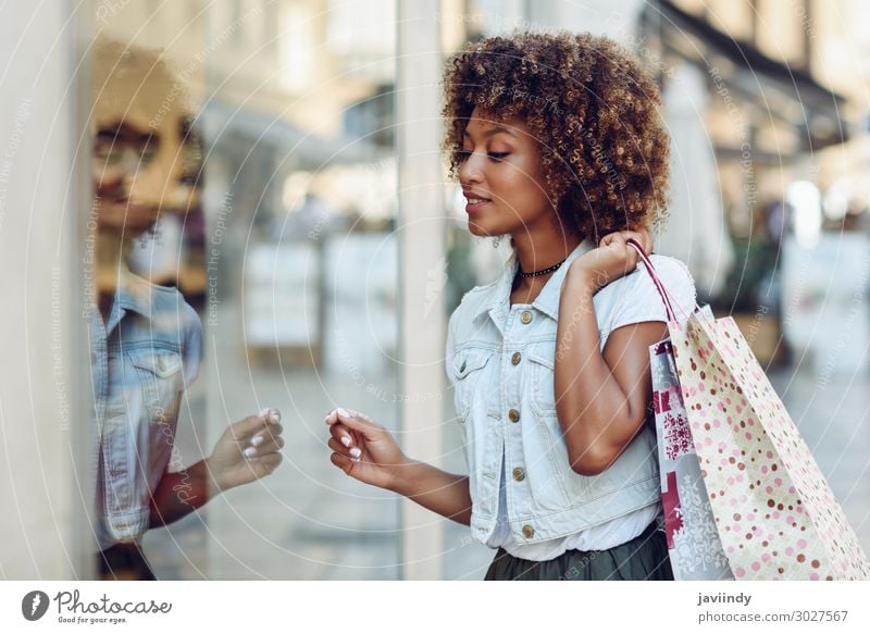 Young black woman in front of a shop window in a shopping street. Lifestyle Shopping Style Happy Beautiful Hair and hairstyles Human being Feminine Young woman