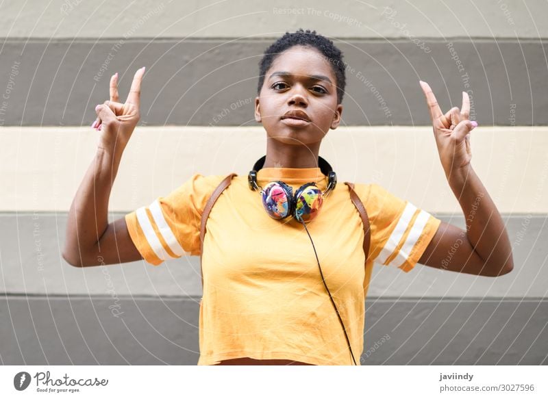 Black woman making the gesture of the horns Style Hair and hairstyles Face Music Headset Human being Feminine Young woman Youth (Young adults) Woman Adults Hand