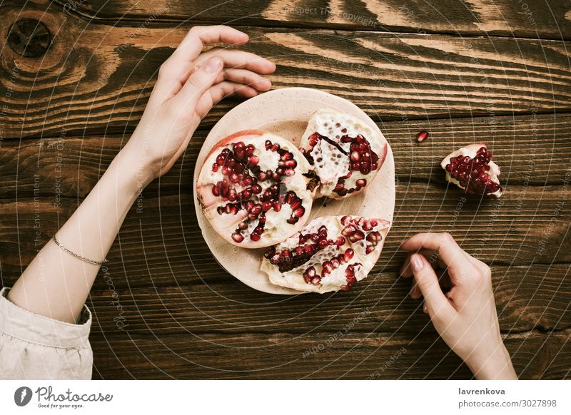 woman's hands and a plate with pomegranate on wooden table Wood Table Vegetarian diet Organic Sweet Healthy Healthy Eating Woman flat lay Food Fruit Hand